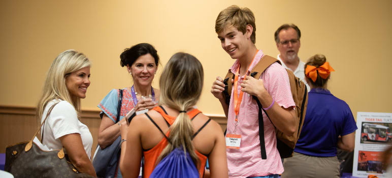 First-year students and their parents stand and talk during Orientation.