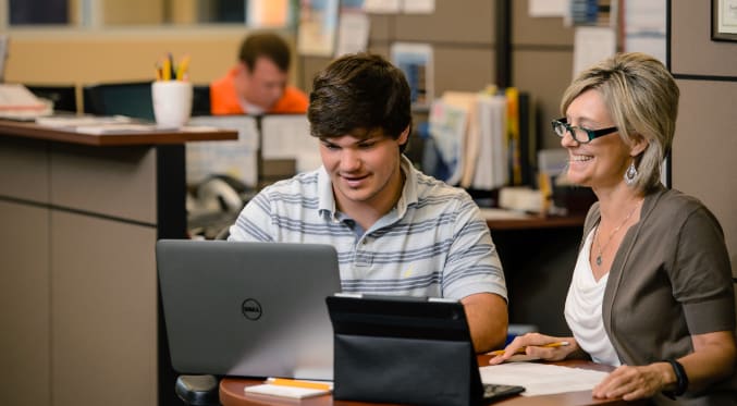 A male student and female professional career advisor sit together at a table in the Michelin Career Center.