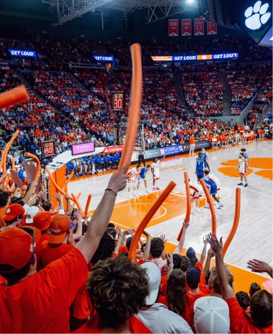 Clemson students and fans wave foam noodles in the stands during a Clemson Mens Basketball game in Littlejohn Coliseum.