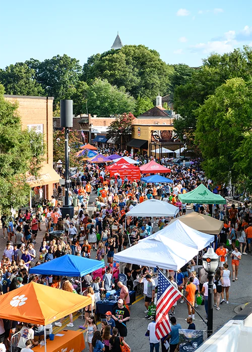 A bird's-eye view of the streets of downtown Clemson, which are filled with people and pop-up tents during a welcome back festival.